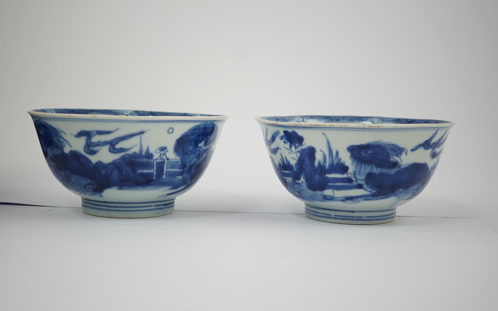 A pair of Chinese Transitional blue and white 'mythical beasts' bowls, early Kangxi period